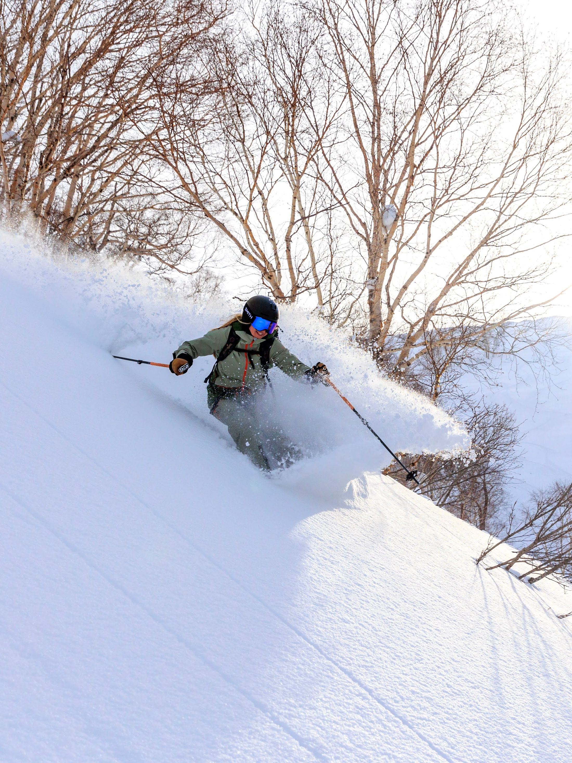 A skier carving through a cloud of fresh powder